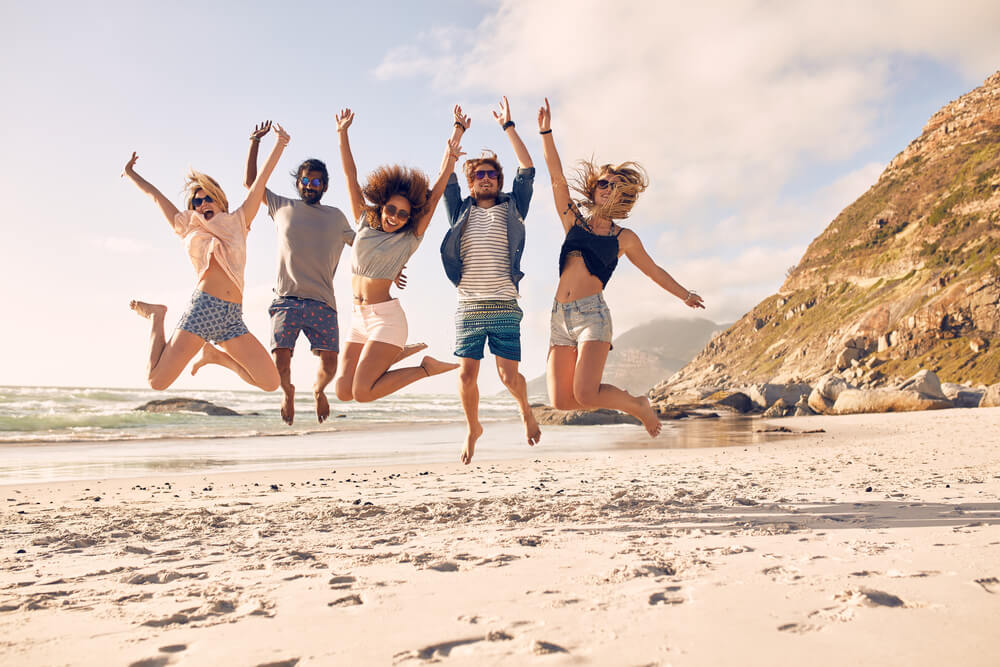 Friends jumping with joy on the beach