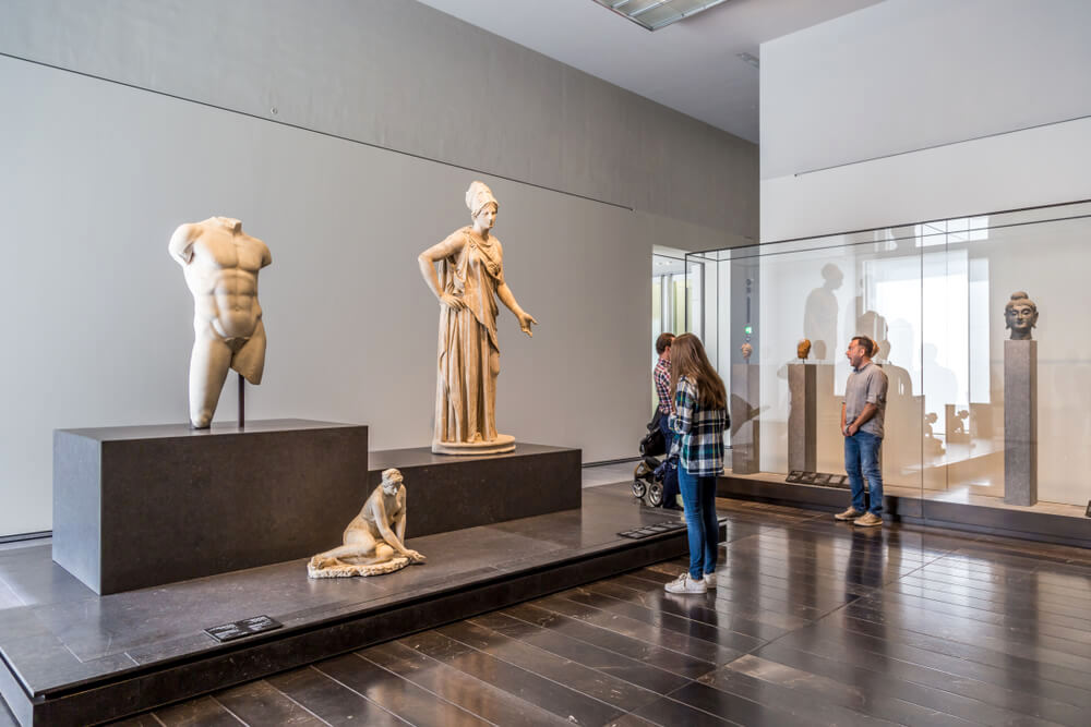 Abu Dhabi, United Arab, Emirates, December 5, 2017: The Louvre. Visitors looking at Greek and Roman sculptures dating from the 5th century BC, on loan from the Louvre, Paris.